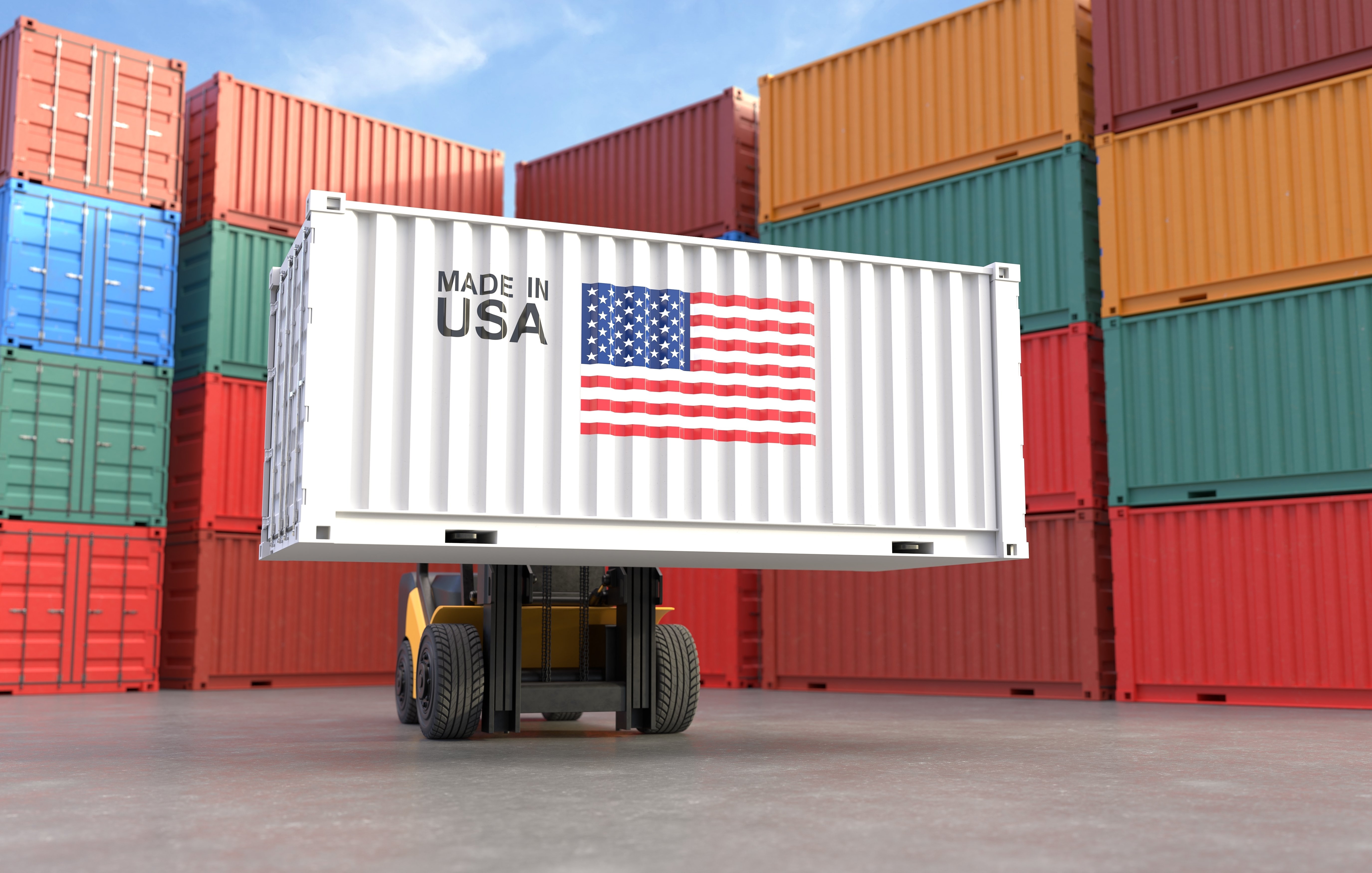 Twenty shipping containers stacked four high surround forklift bearing shipping container with image of U.S. flag and words “Made in USA.”