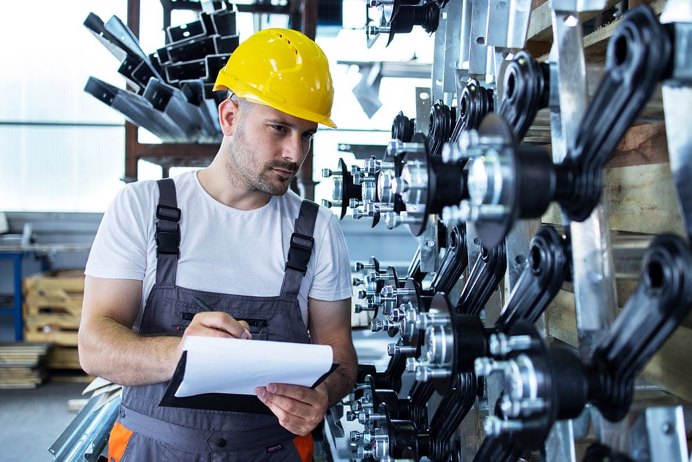 Procurement team member inspects industrial MRO parts in a facility, illustrating common sourcing oversights in maintenance supply chains.