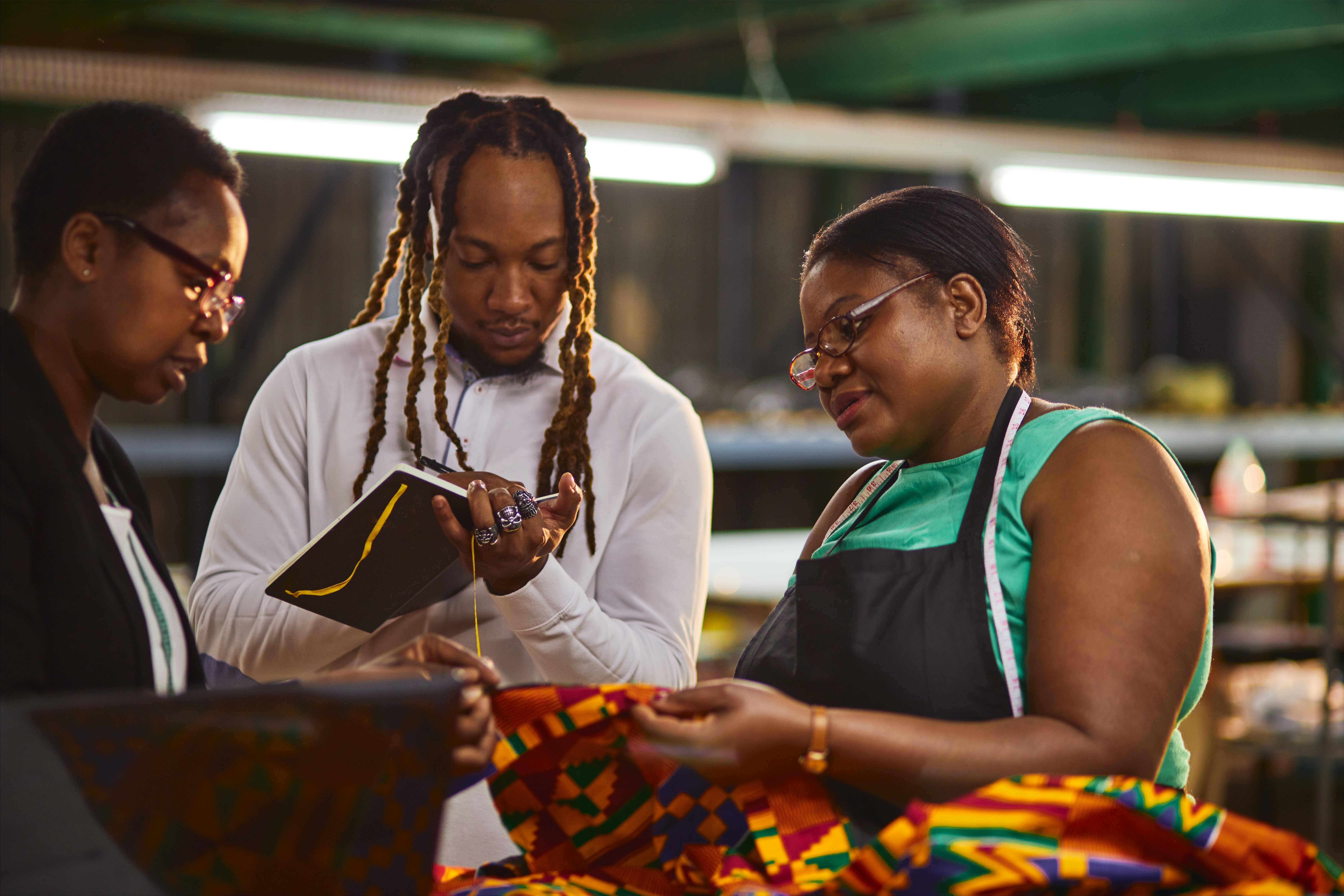 Manager and employees of a minority-owned textile company inspect the quality of their product before shipping.